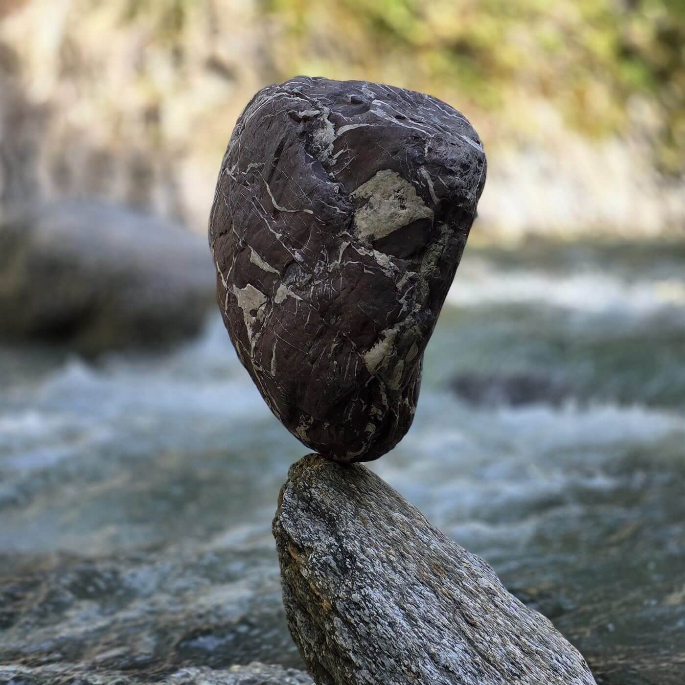Balancierter Stein auf einem weiteren Stein im fließenden Wasser
